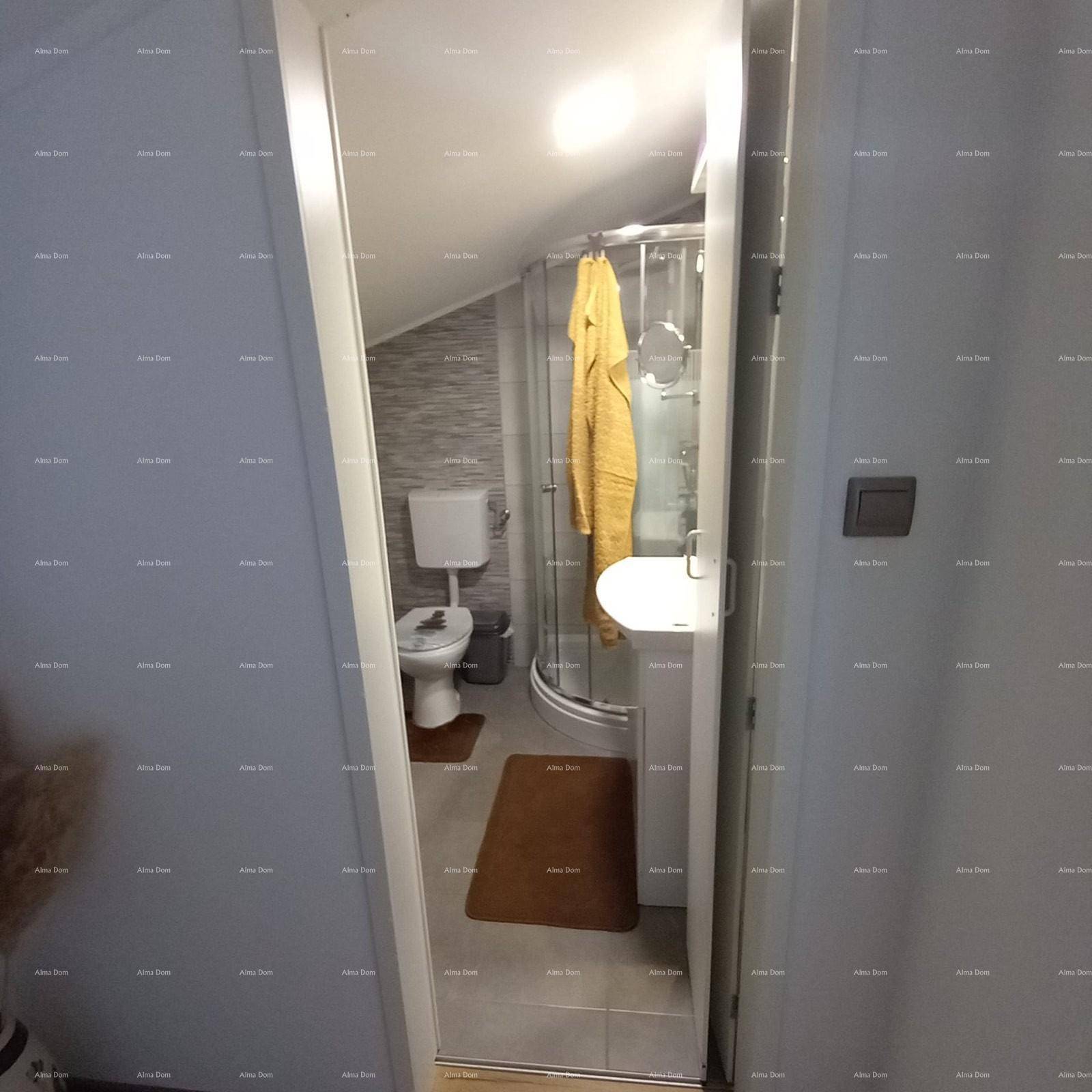 Modernes Badezimmer im Dachgeschoss mit Dusche, WC und Waschbecken.