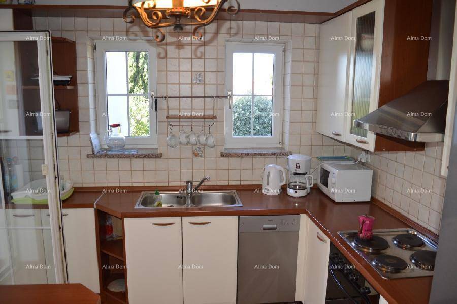 Helle Küche mit beigen Fliesen, Holz-Arbeitsplatten und integrierten Geräten für den täglichen Gebrauch.