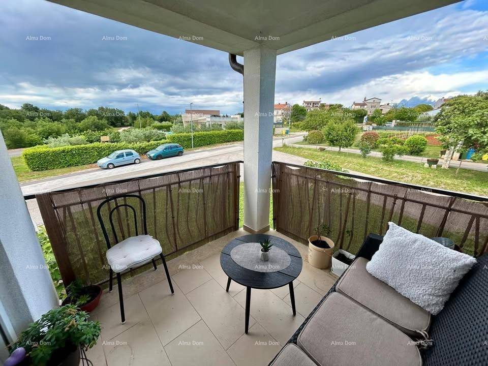 Gemütlicher Balkon mit Sitzgelegenheiten und Blick auf die grüne Umgebung und Straße.