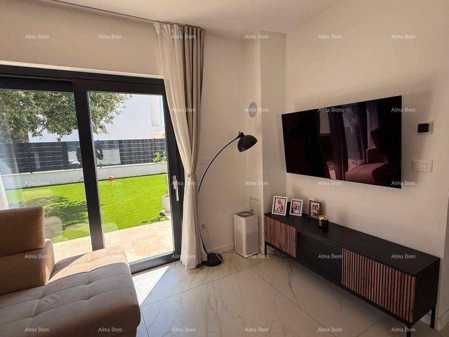 Heller Wohnbereich mit Wandfernseher, modernem Sideboard und Schiebetür zum Garten.