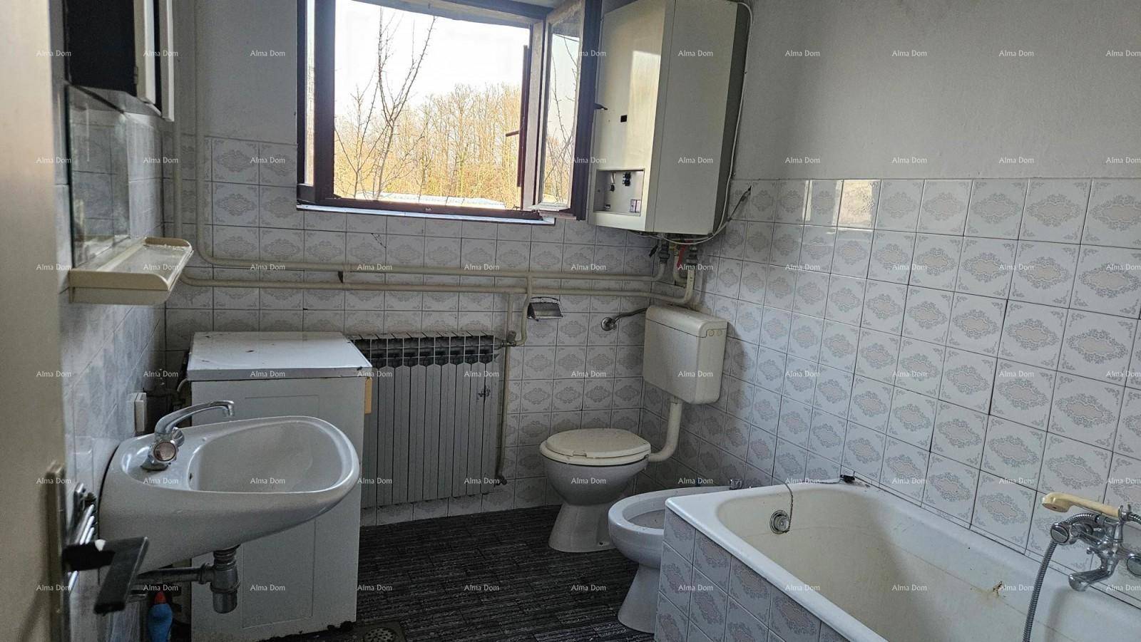 Badezimmer mit Badewanne, Toilette, Bidet und einem Fenster für natürliche Belüftung und Licht.