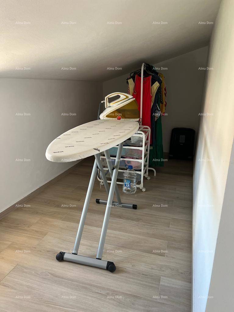 Praktischer Hauswirtschaftsraum im Dachgeschoss mit Bügelbrett und Stauraum.