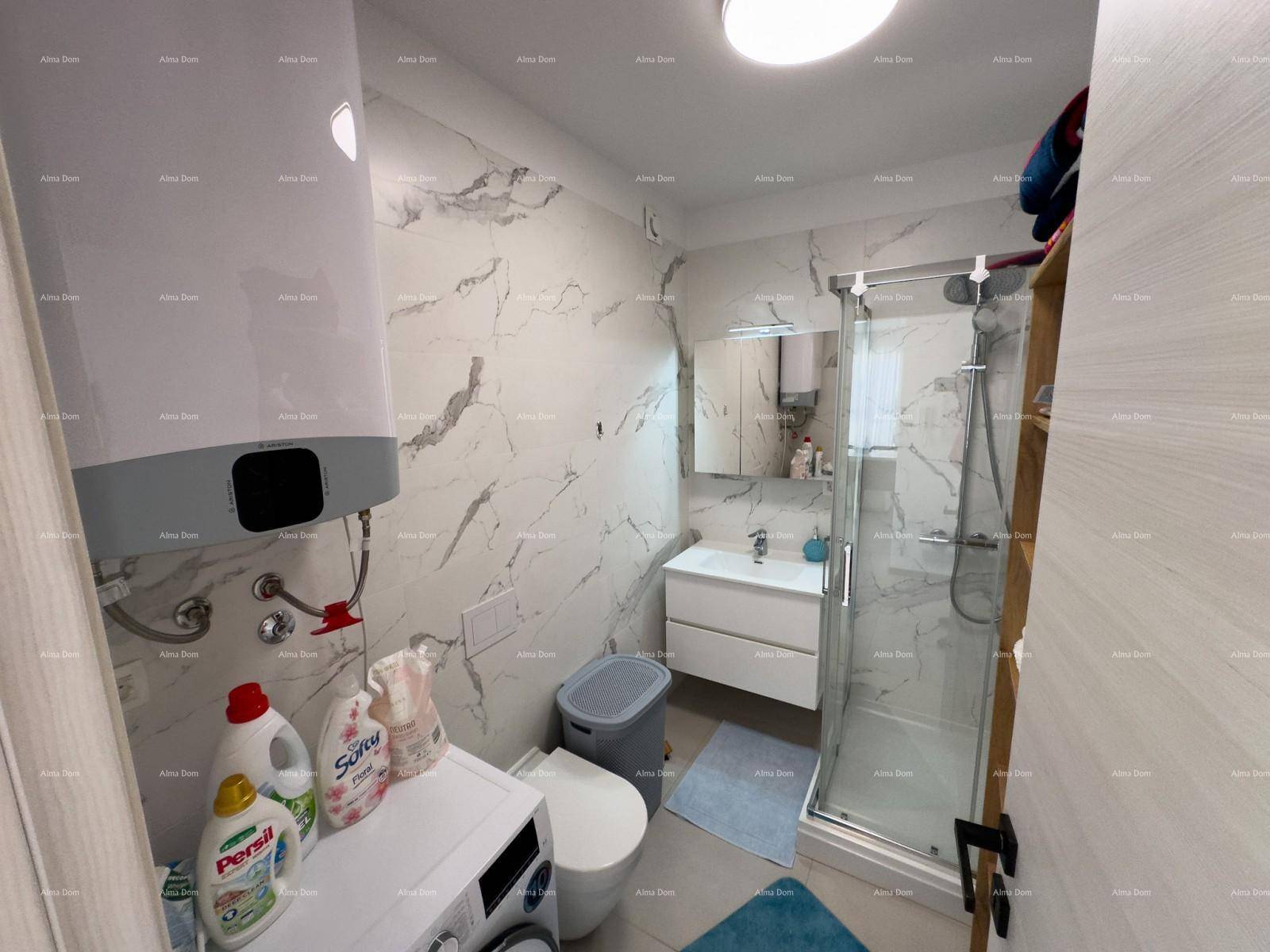 Funktionales Badezimmer mit Waschmaschine, Warmwasserboiler und Duschbereich.