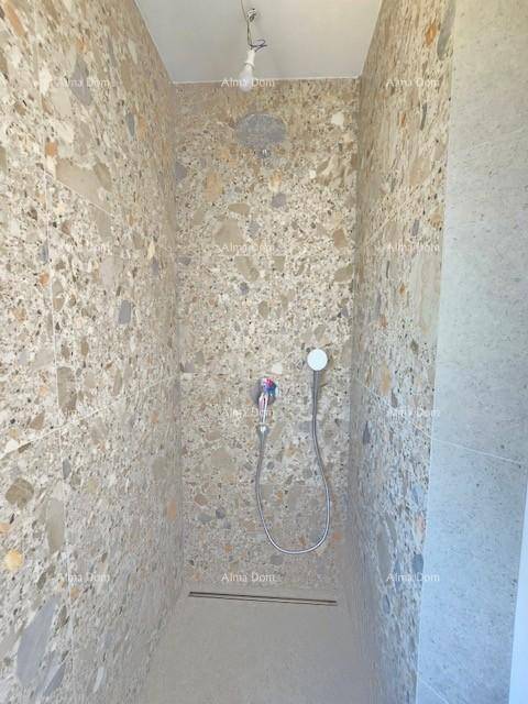 Moderne begehbare Dusche mit stilvollen Fliesen und Duscharmatur, für ein luxuriöses Duscherlebnis.