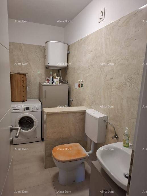 Funktionaler Waschraum mit Toilette, Waschmaschine und Warmwasserbereiter, gefliest.