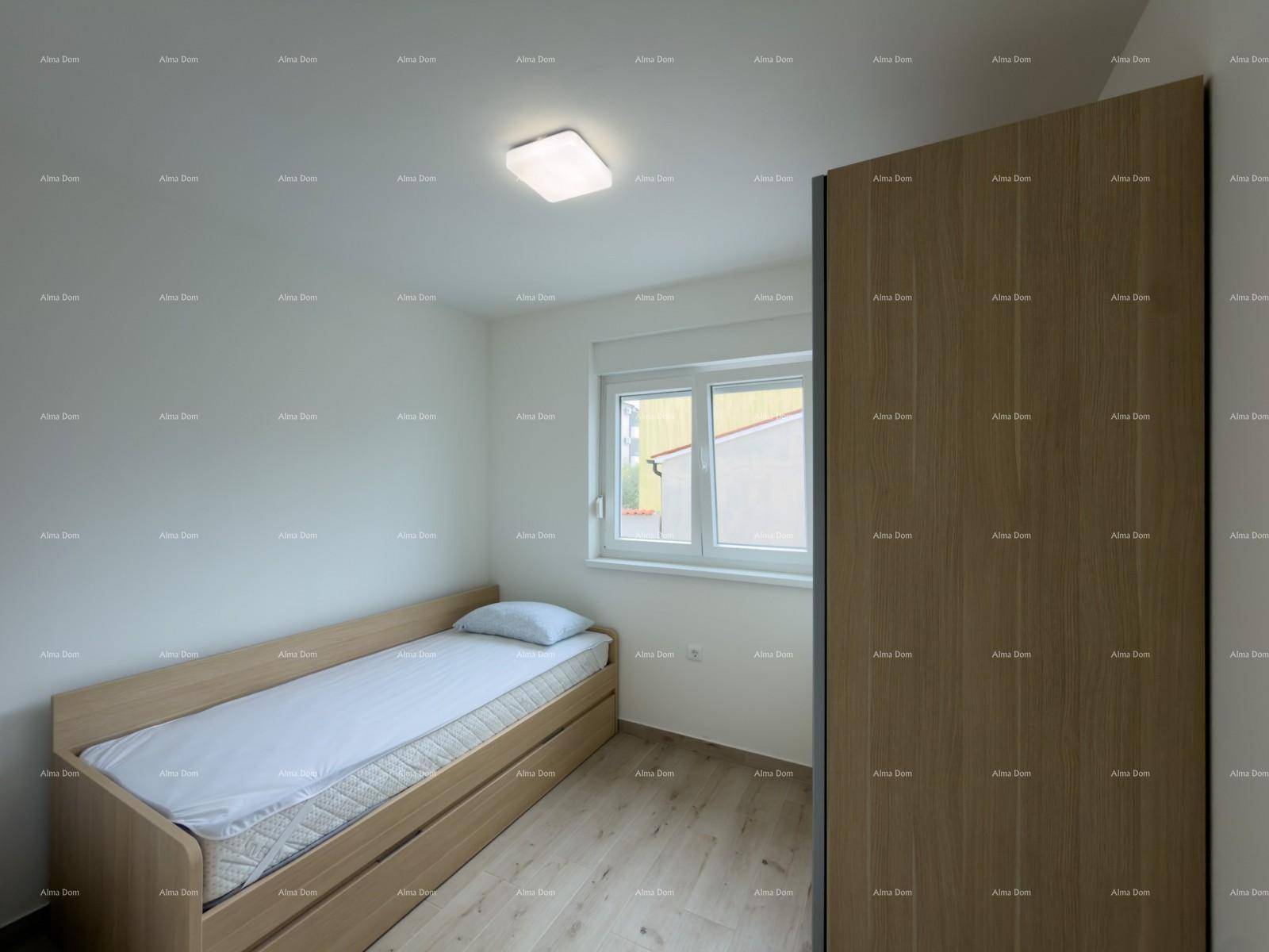 Helles Schlafzimmer mit Einzelbett, Holzschrank und Laminatboden.