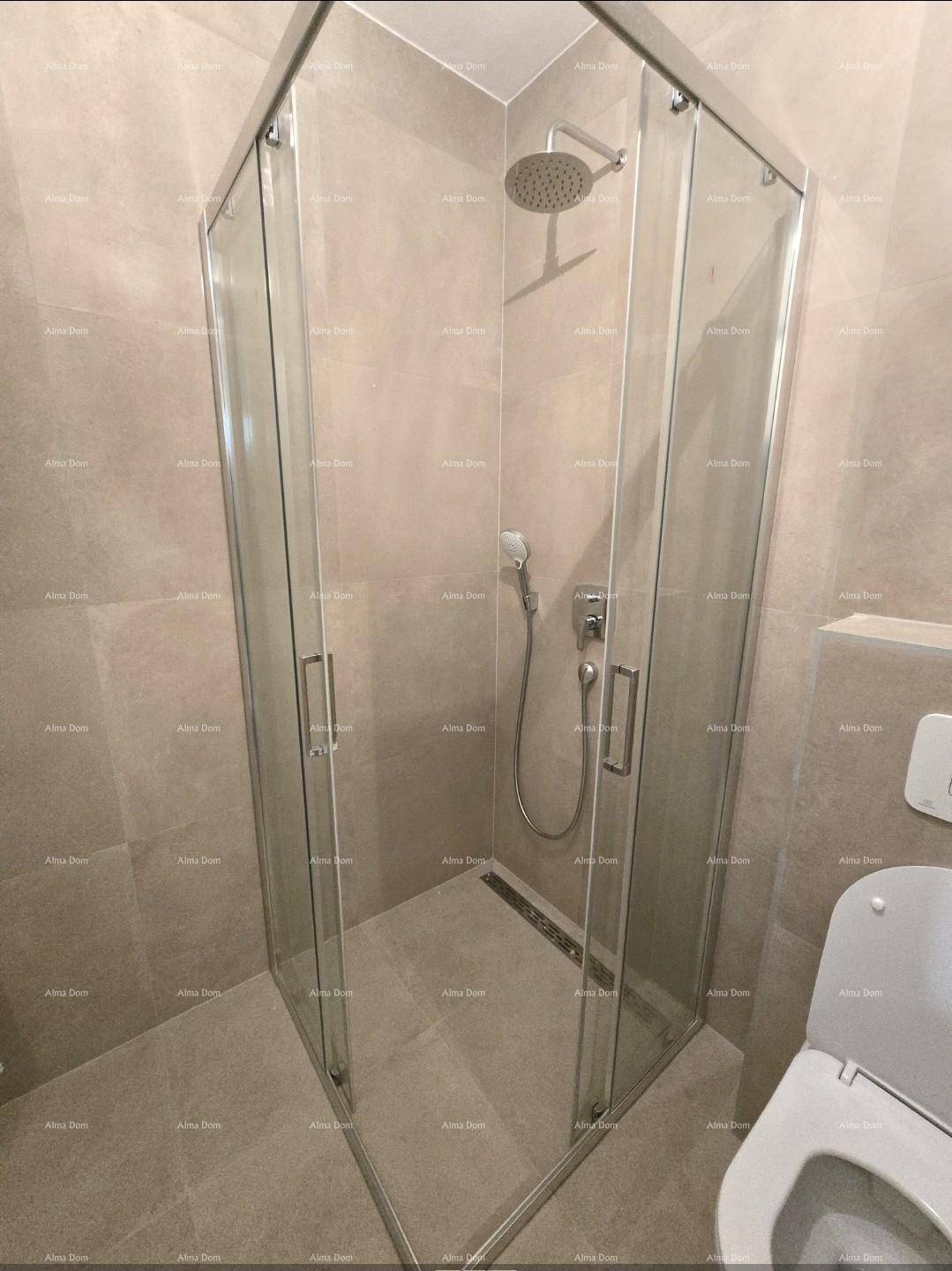 Duschkabine aus Glas in einem modern gefliesten Badezimmer mit Regendusche.
