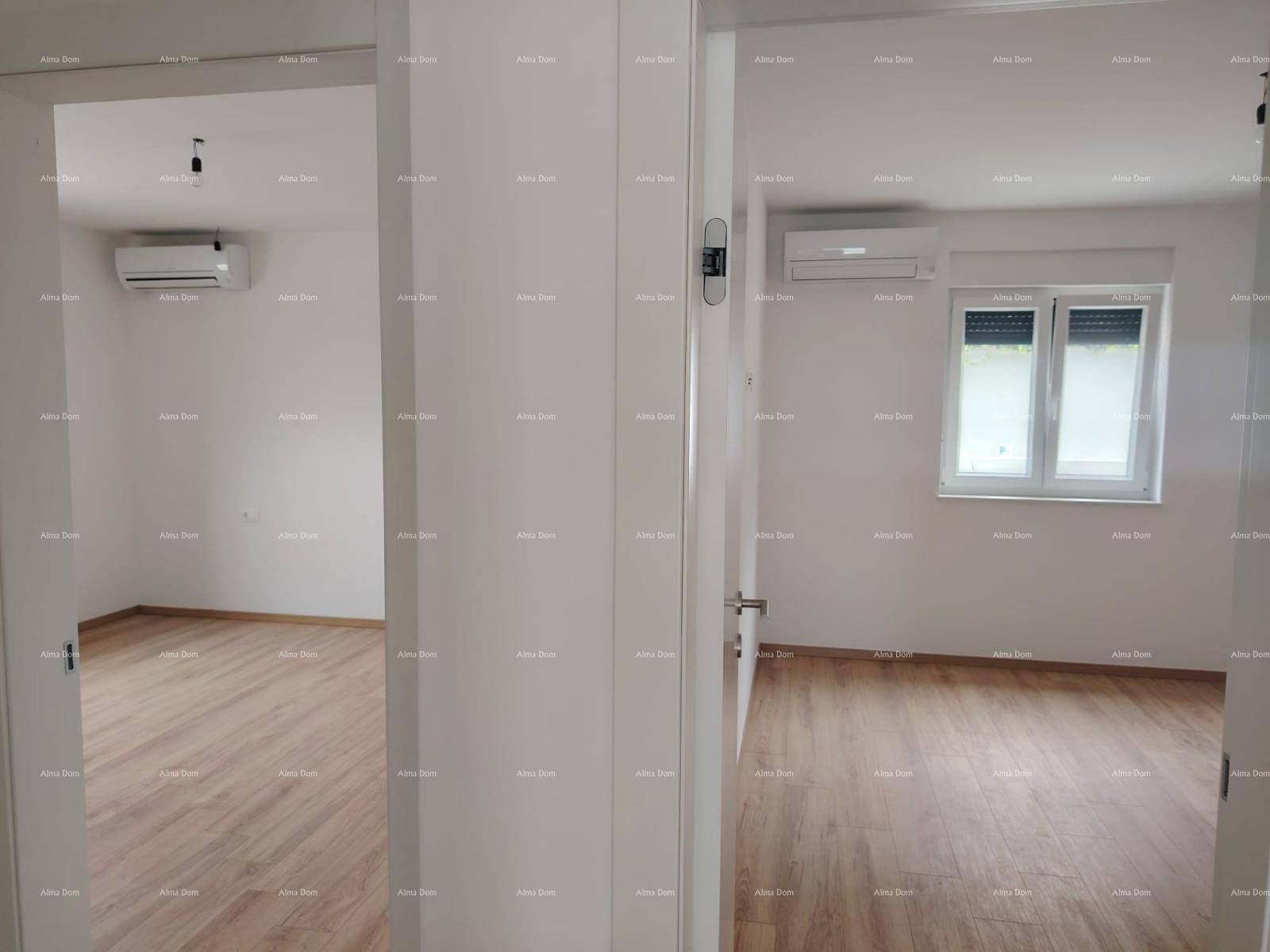 Zwei helle, leere Räume mit Laminatboden und Klimaanlage, durch Türen getrennt.