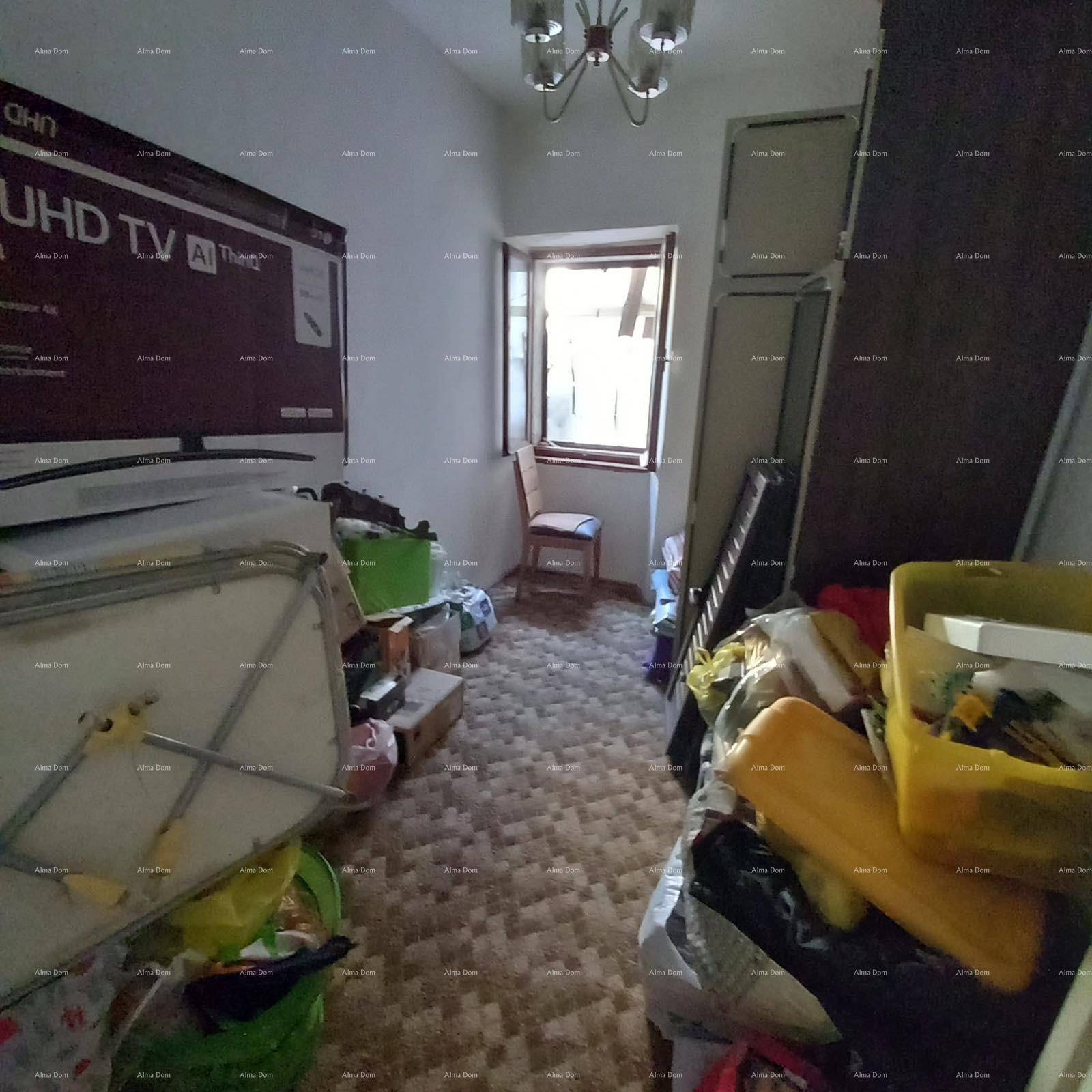 Unaufgeräumter Raum mit Fenster und vielen Gegenständen, möglicherweise ein Abstellraum.
