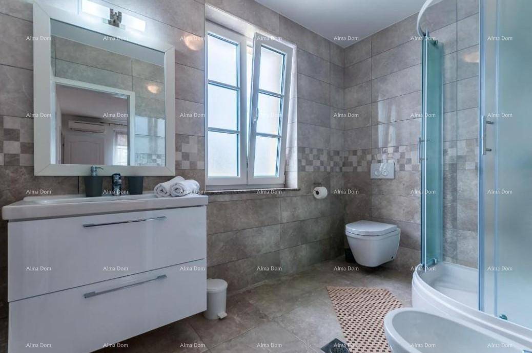 Modernes Badezimmer mit Duschkabine, Einzelwaschbecken und Fenster, das für Helligkeit sorgt.
