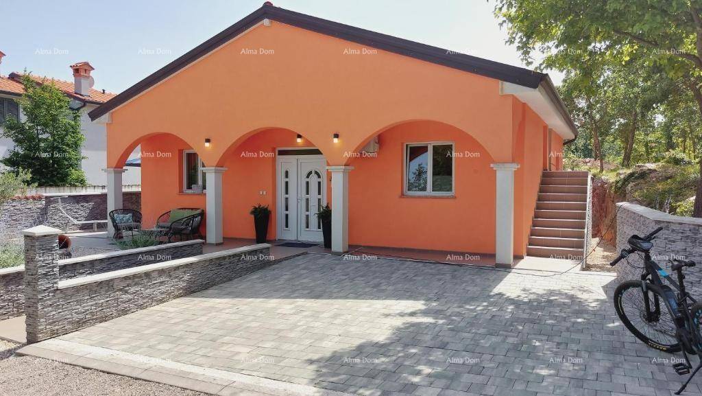 Tagesansicht des modernen Hauses mit gepflasterter Auffahrt und Außentreppe.