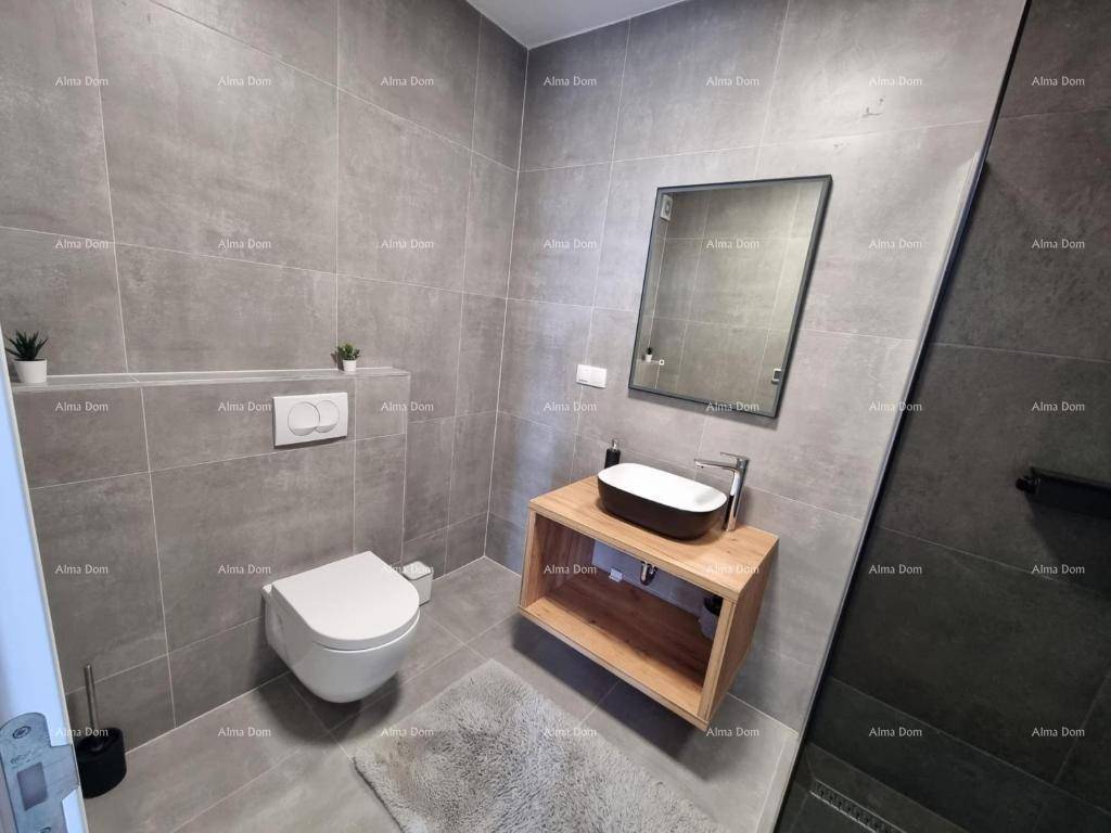 Modernes Gäste-WC mit grauen Fliesen, Wand-WC und einem stilvollen Aufsatzwaschbecken aus Holz.