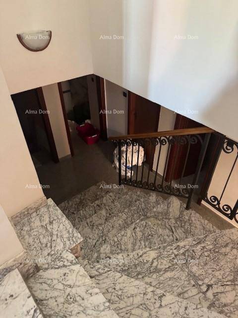 Marmortreppe mit schmiedeeisernem Geländer, die in einen unteren Bereich führt.