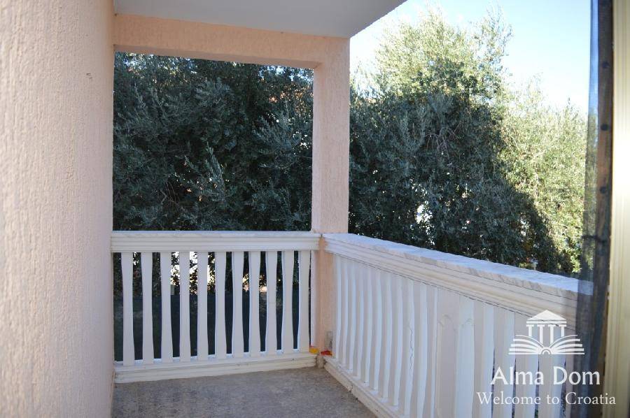 Kleiner Balkon mit weißem Geländer und Blick ins Grüne, ideal für entspannte Stunden.