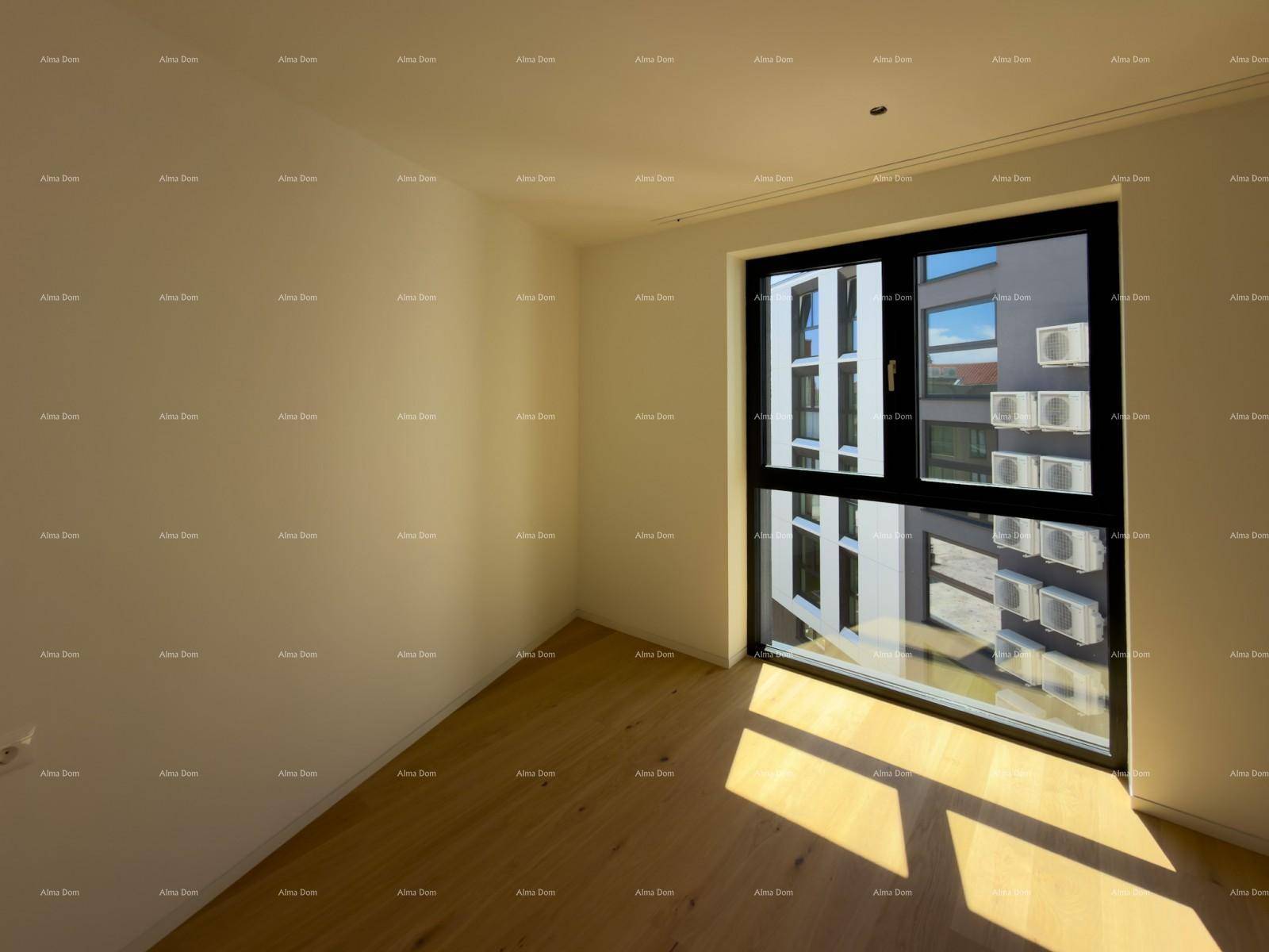 Lichtdurchflutetes Zimmer mit Holzboden und großem Fenster mit Blick auf gegenüberliegende Gebäude.