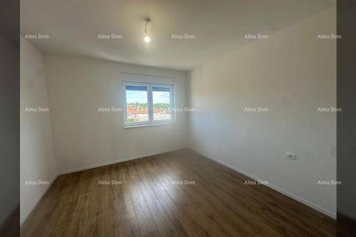 Geräumiges Schlafzimmer mit Laminatboden und einem Fenster, das viel natürliches Licht spendet.
