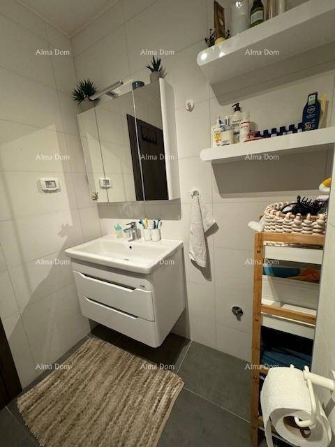 Helles Badezimmer mit modernem Waschtisch, Spiegelschrank und praktischen Ablagen.