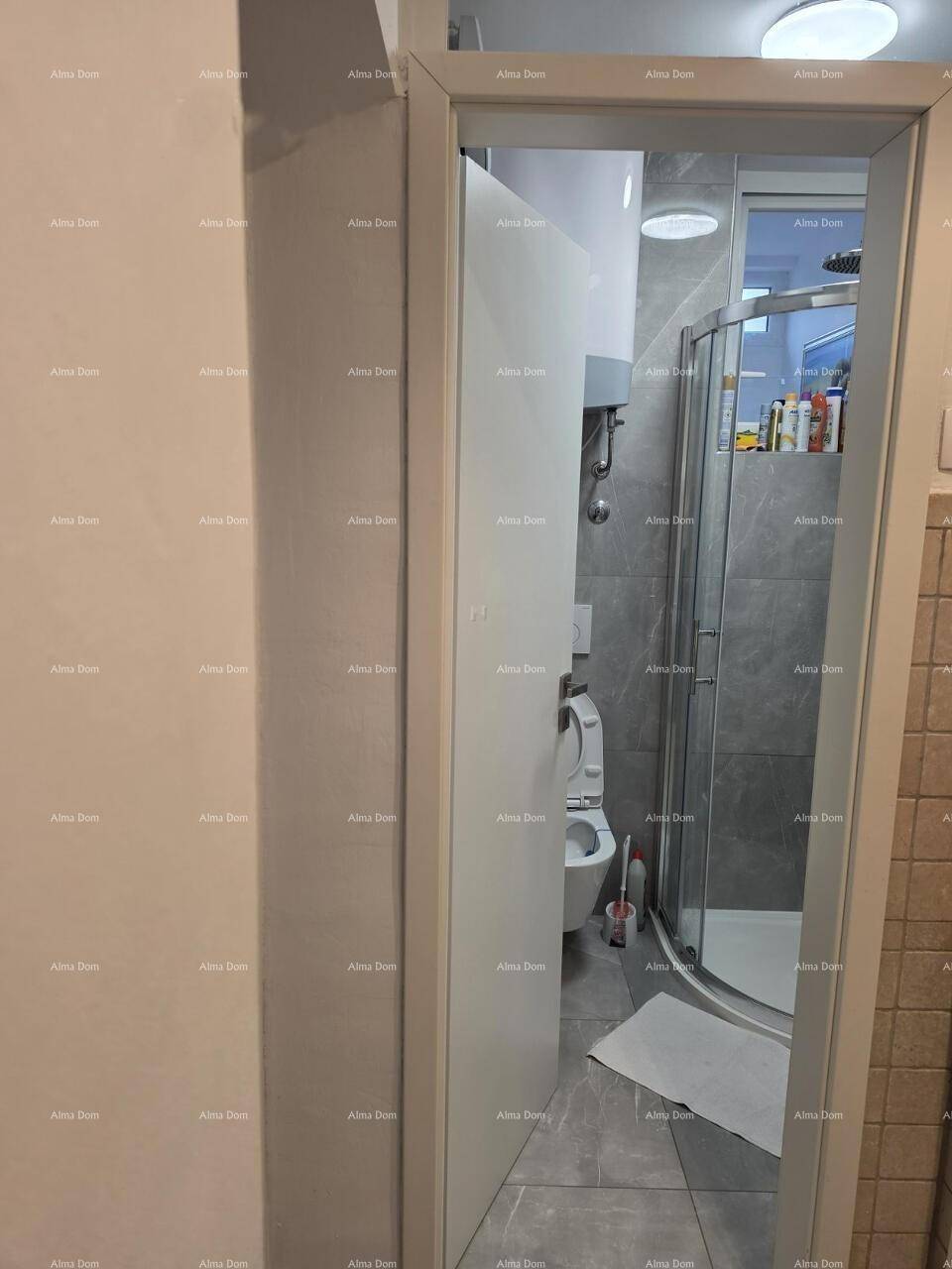 Blick in ein modernes Badezimmer mit Duschkabine und Wand-WC.