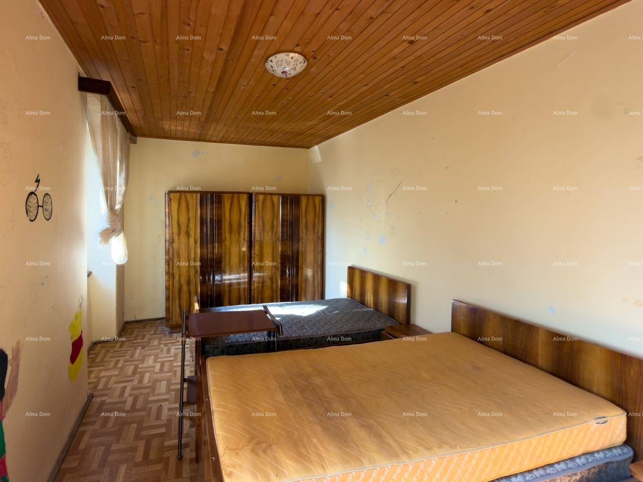 Schlafzimmer mit Holzdecke, zwei Betten und einem großen Kleiderschrank, mit gemustertem Boden.