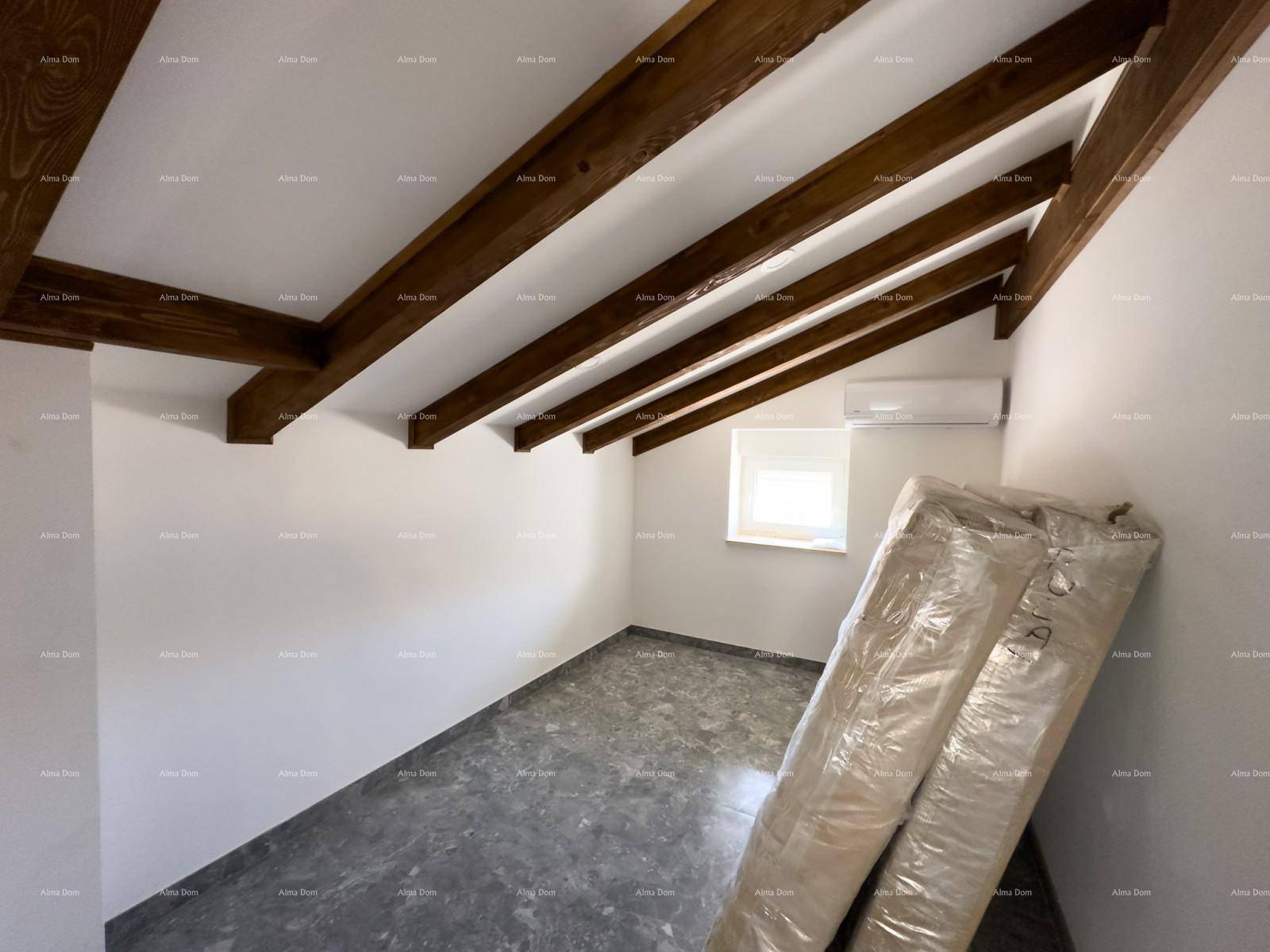 Helles Dachgeschoss-Zimmer mit sichtbaren Holzbalken, schräger Decke und Klimaanlage, bereit zur Einrichtung.