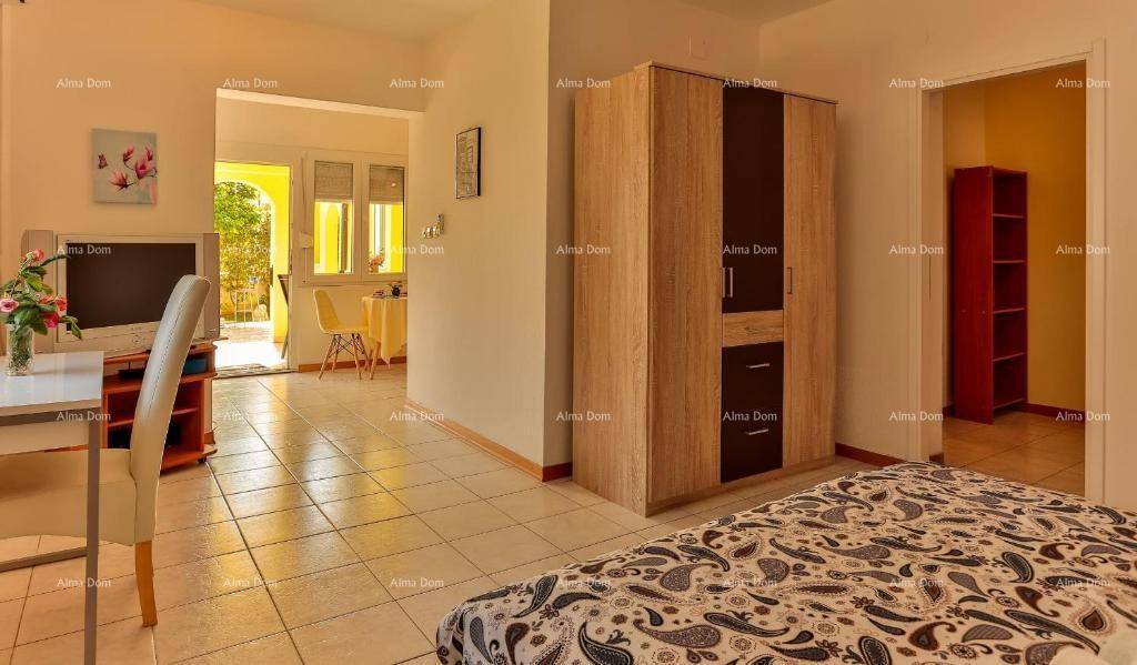 Schlafzimmer mit Doppelbett, Kleiderschrank und Blick in den Wohnbereich.