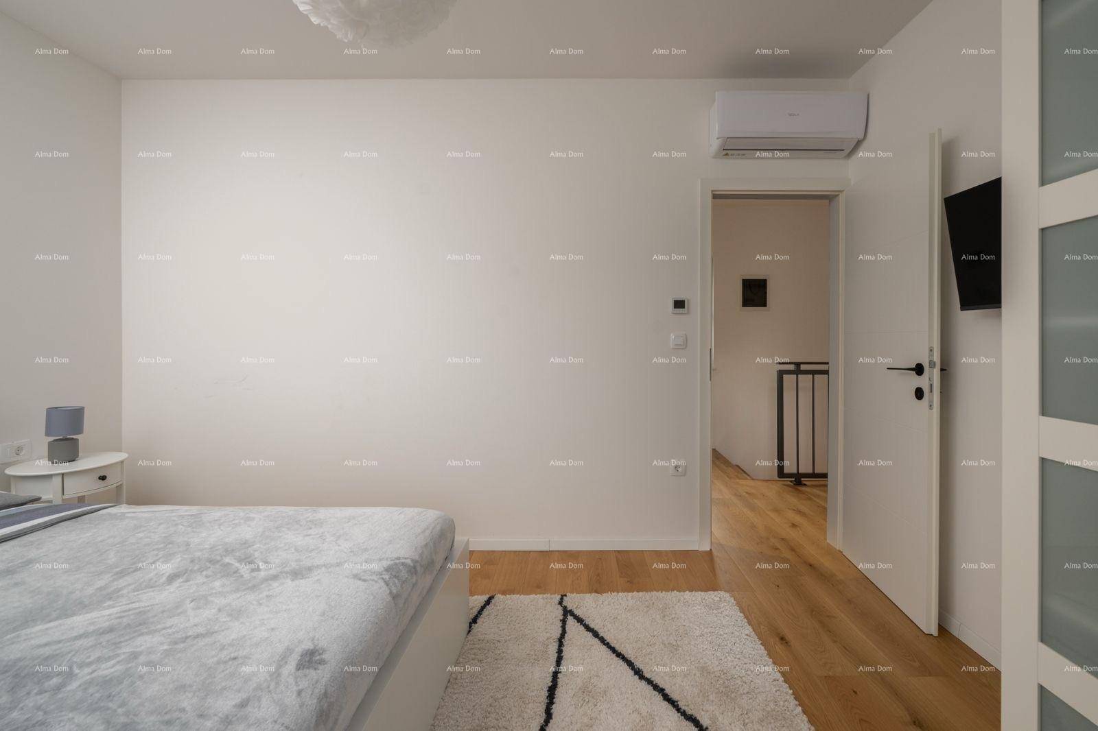Helles Schlafzimmer mit Holzboden, Klimaanlage und Blick auf den Flur.