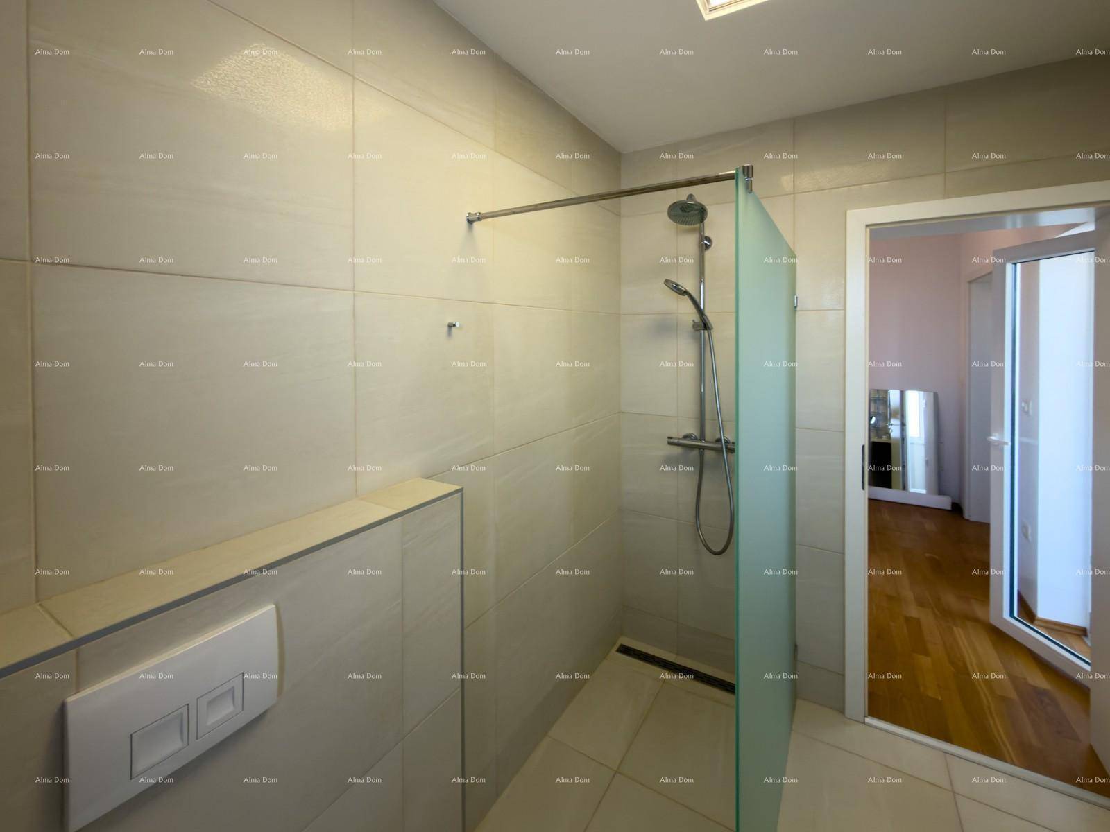 Geräumige, begehbare Dusche mit Glasabtrennung und modernen beigefarbenen Wandfliesen.