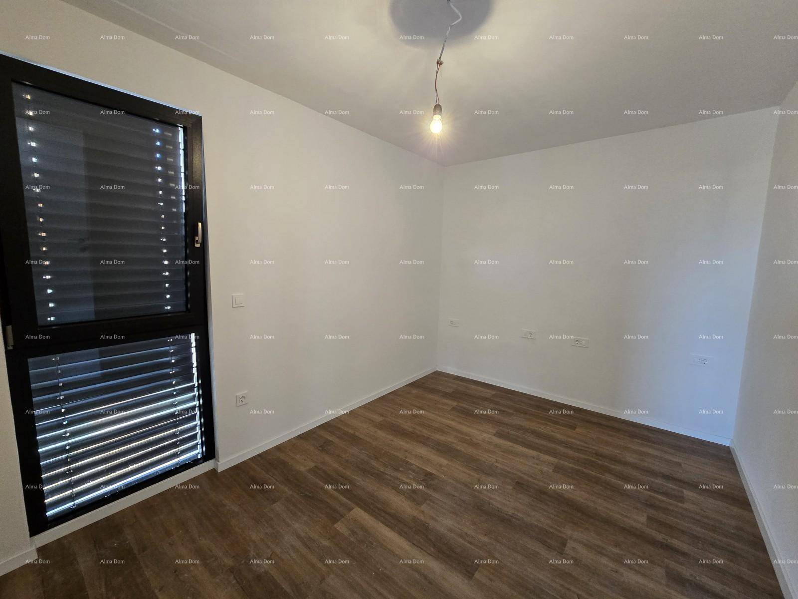 Leeres Schlafzimmer mit Holzboden und einem Fenster mit geschlossenen Jalousien.