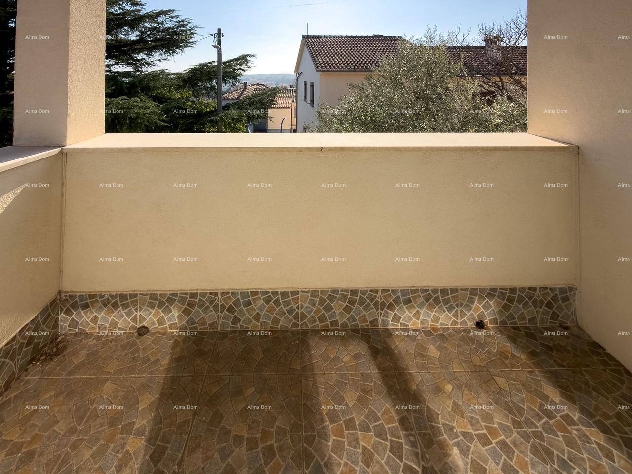 Kleiner Balkon mit gemusterten Fliesen und Blick auf die Umgebung.