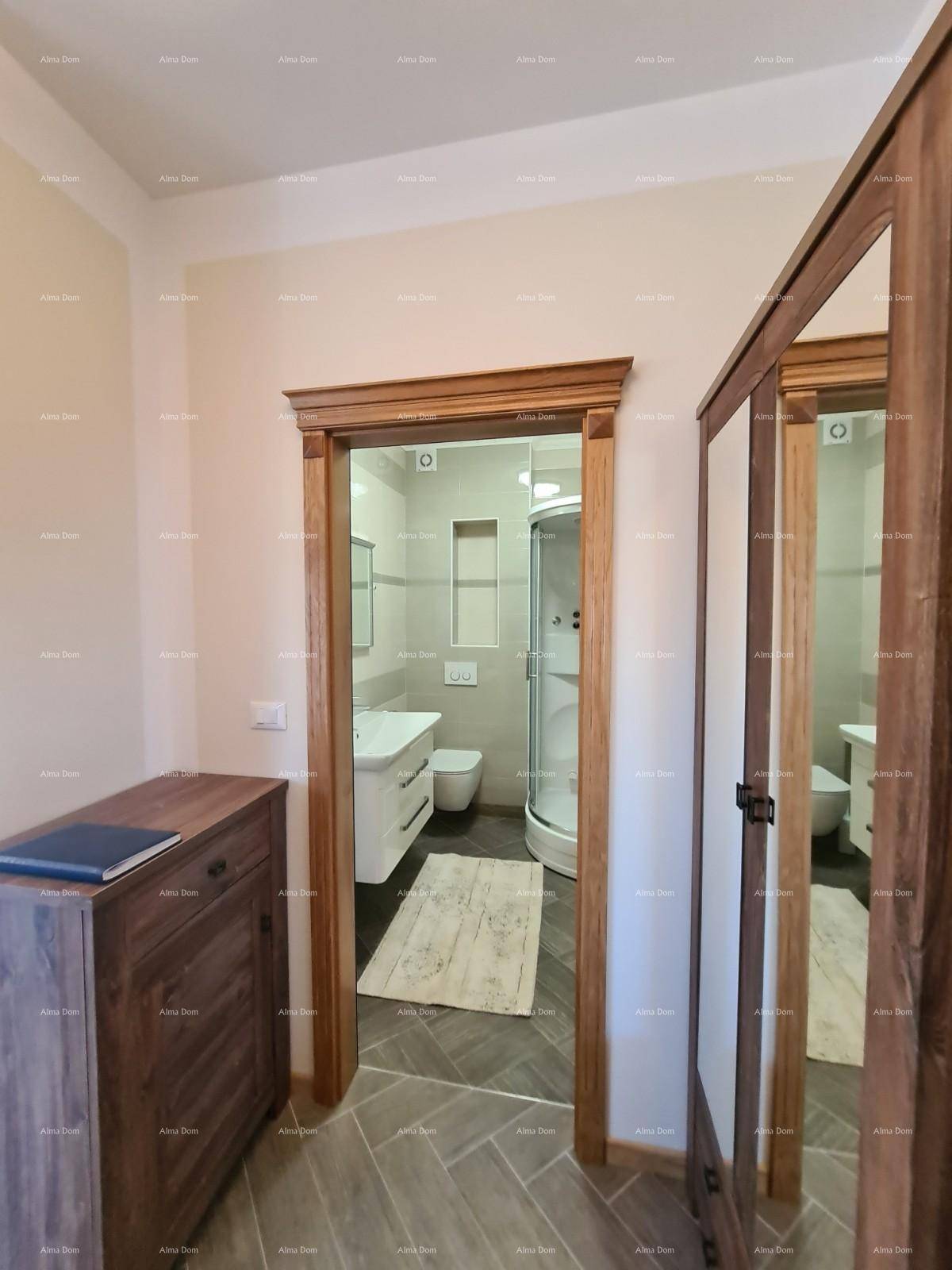 Flur mit Holzrahmen und Blick in ein modernes Badezimmer mit Duschkabine.