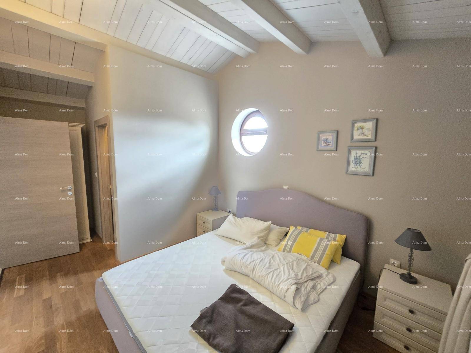 Gemütliches Schlafzimmer mit Doppelbett, runden Fenstern und traditioneller Holzbalkendecke.
