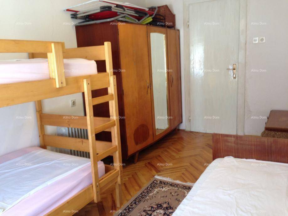 Schlafzimmer mit Etagenbett, Kleiderschrank und Holzboden.