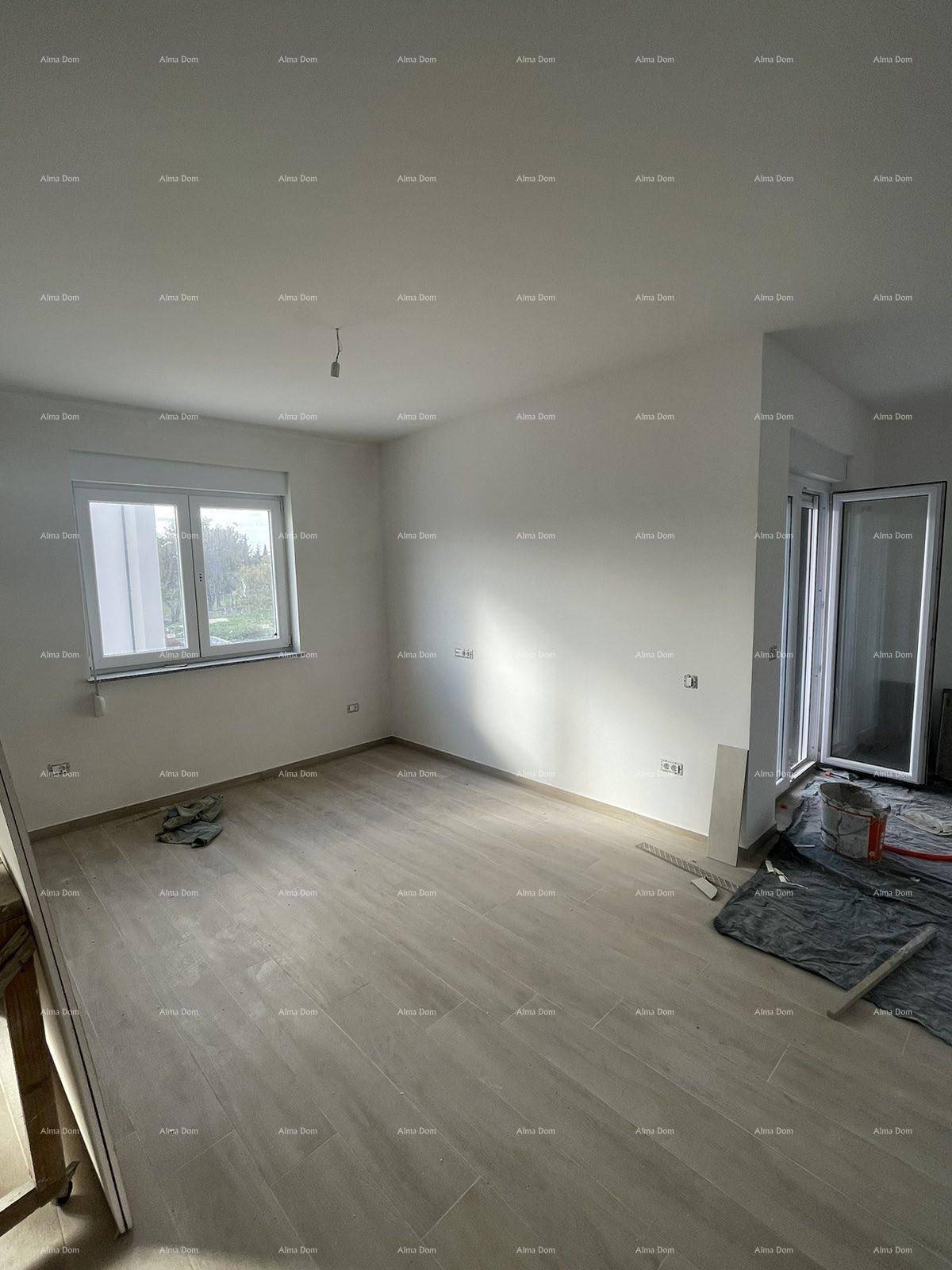 Heller Wohnbereich im Rohbau mit Fliesenboden, großem Fenster und Zugang zu einem Außenbereich.