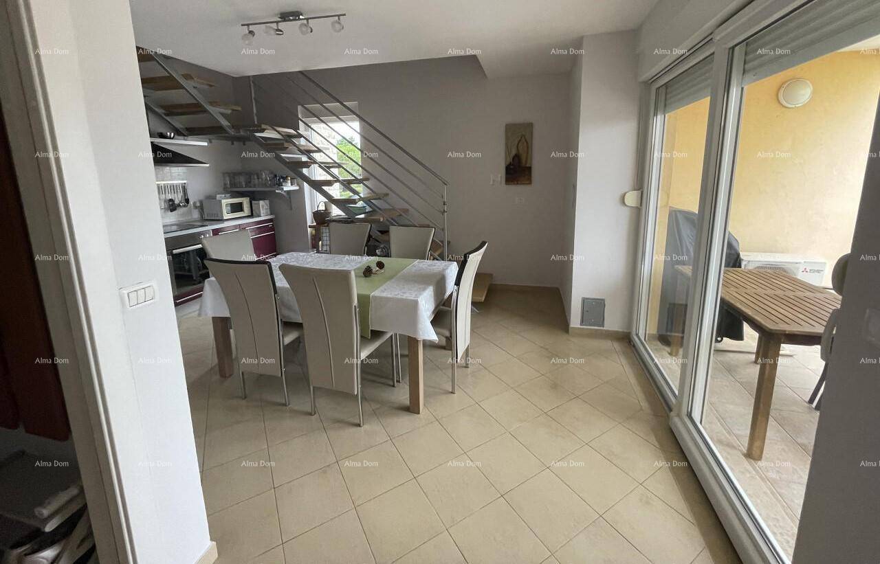 Heller Wohn- und Essbereich mit Zugang zu einem Balkon oder einer Terrasse, gefliestem Boden und Treppe.