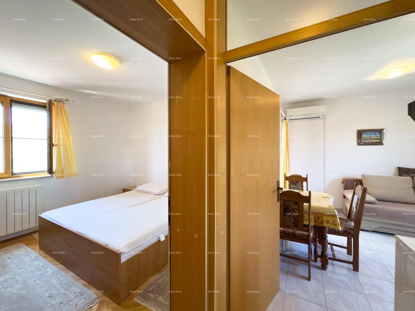 Flur mit Zugang zu einem Schlafzimmer und einem kombinierten Wohn-Essbereich.