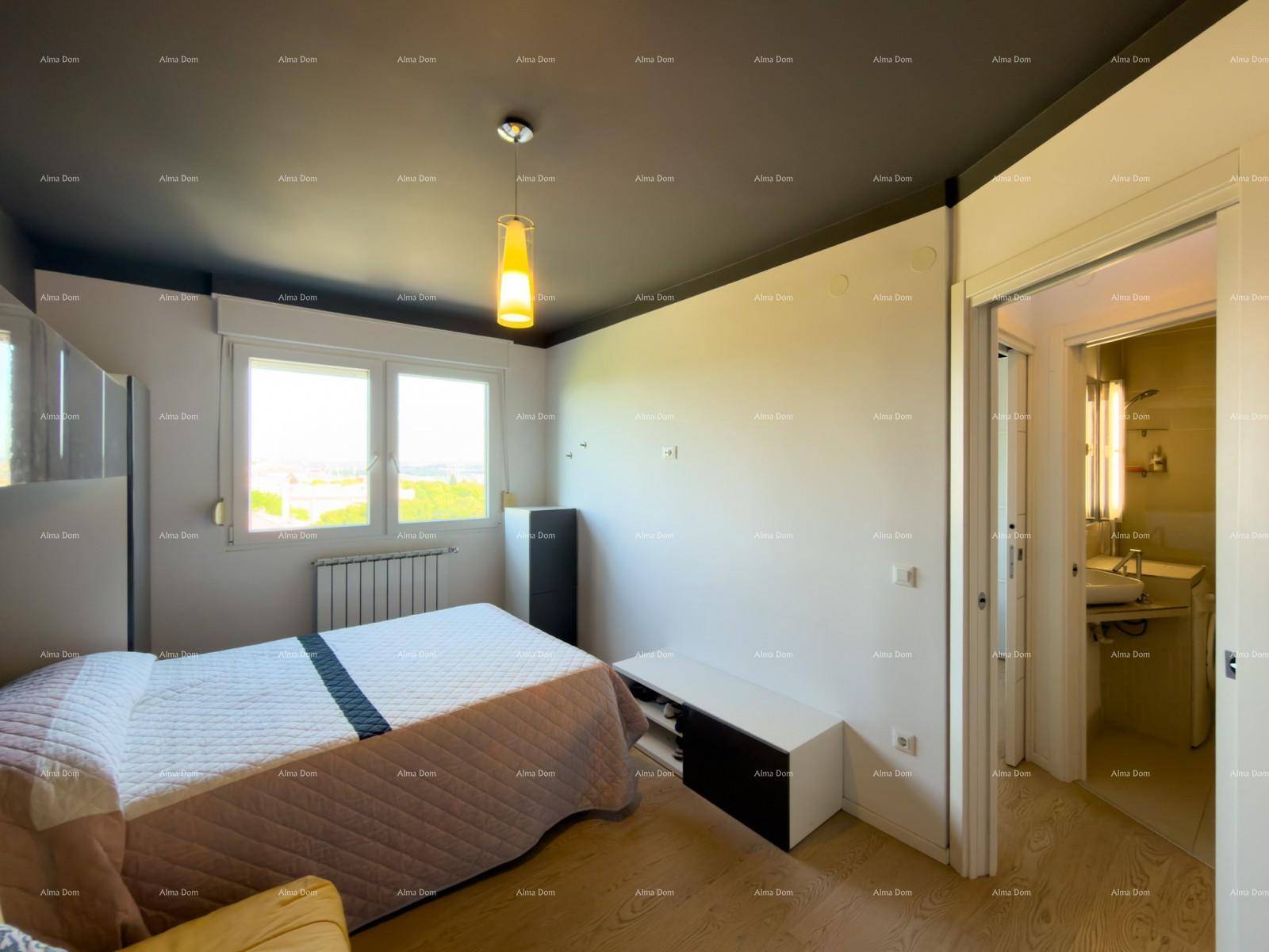Schlafzimmer mit Doppelbett, Fenster und Zugang zu einem modernen Badezimmer.