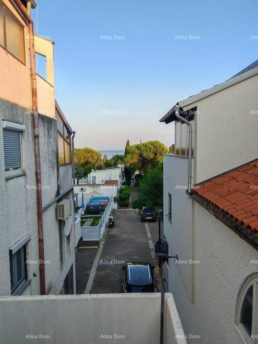 Blick auf eine schmale Straße zwischen Gebäuden mit dem Meer in der Ferne.
