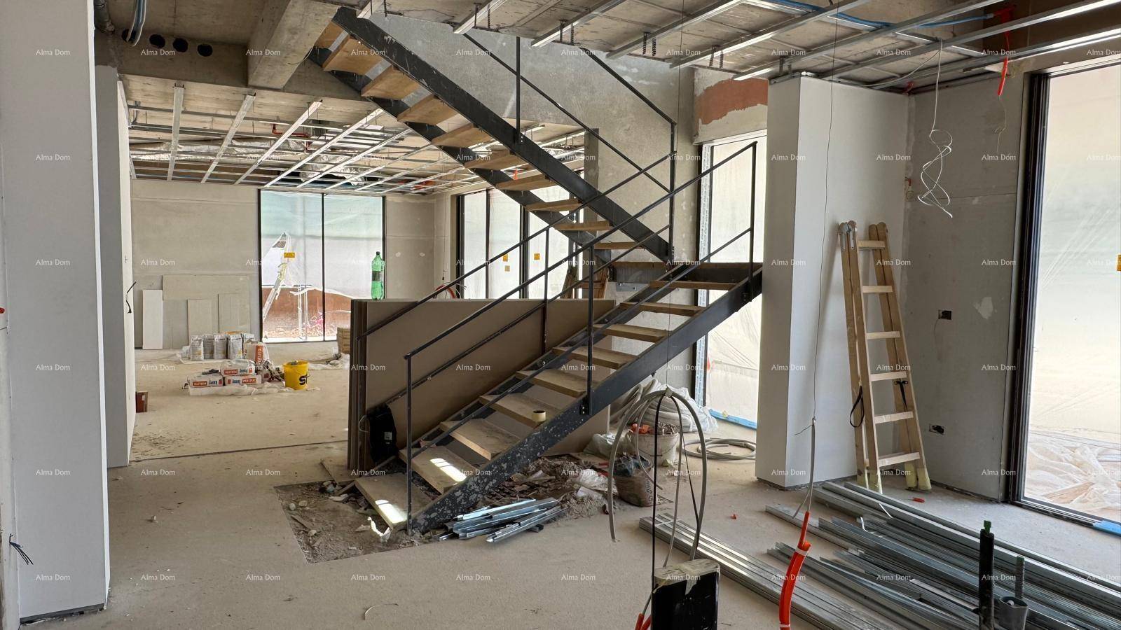 Treppenhaus im Rohbau mit Holzstufen und Metallgeländer, bereit für den weiteren Ausbau.