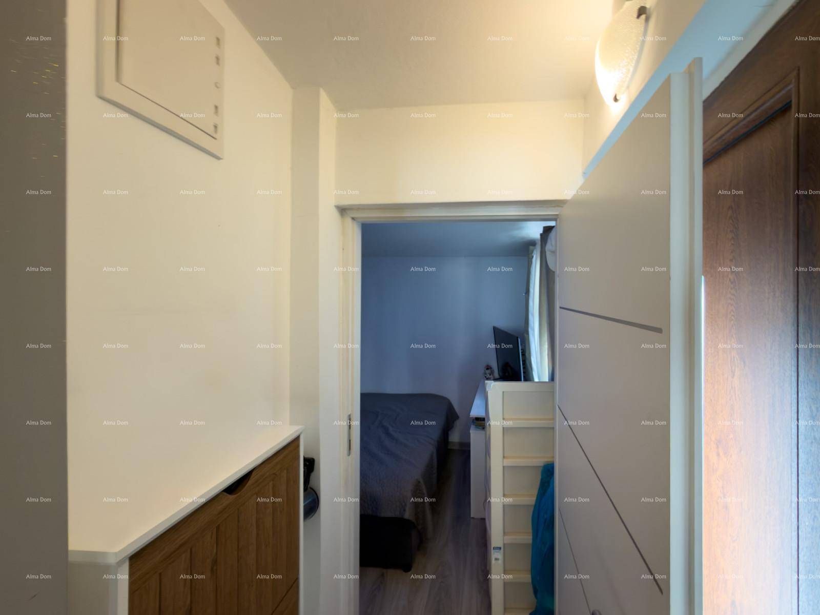 Heller Flur mit Holzakzenten und Blick in ein angrenzendes Schlafzimmer.
