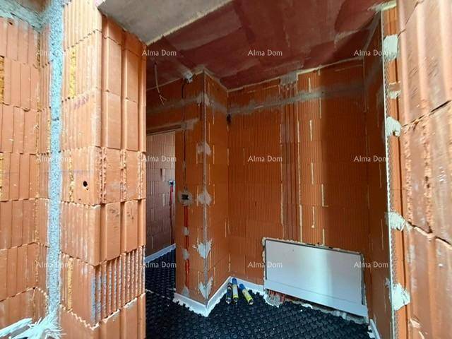Unfertiger Eingangsbereich mit Ziegelwänden und Heizkörpervorbereitung, bereit für den Ausbau.