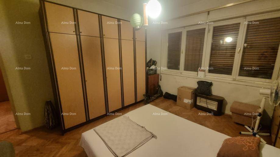 Schlafzimmer mit einem Bett, großen Kleiderschränken und einem Fenster, das Tageslicht hereinlässt.
