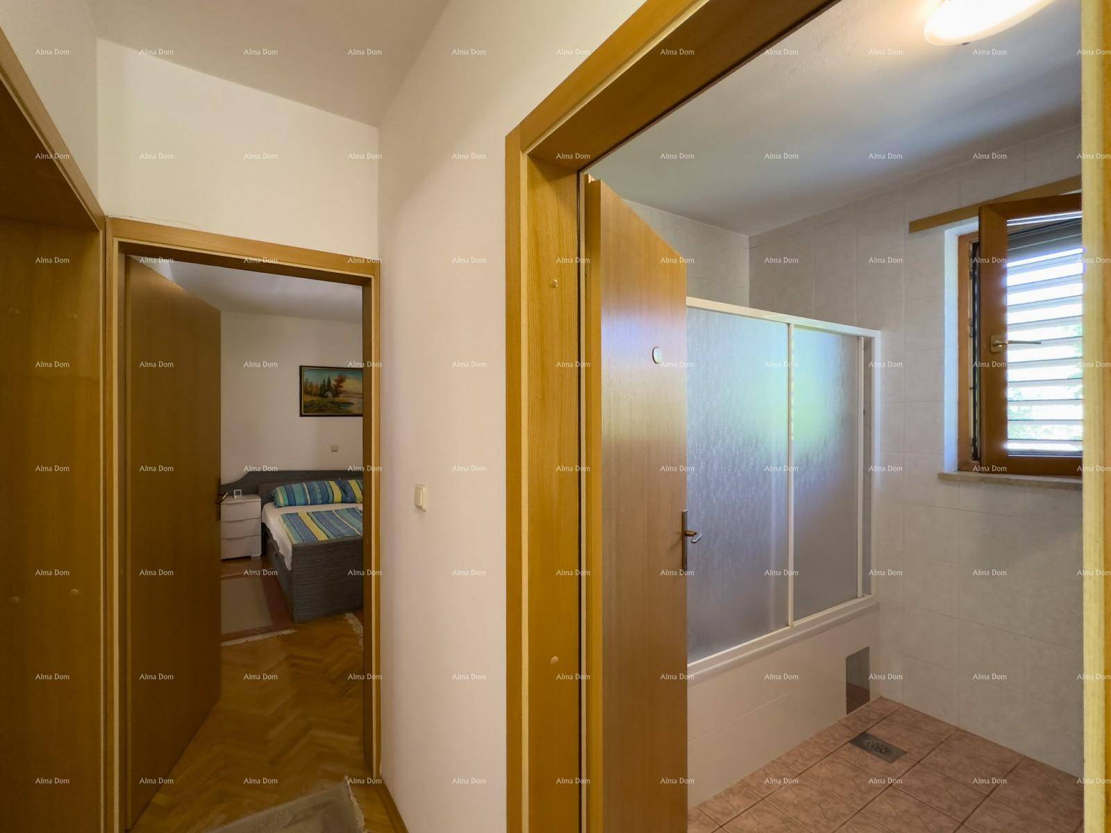 Flur mit Zugang zu einem Badezimmer mit Dusche und einem Schlafzimmer.