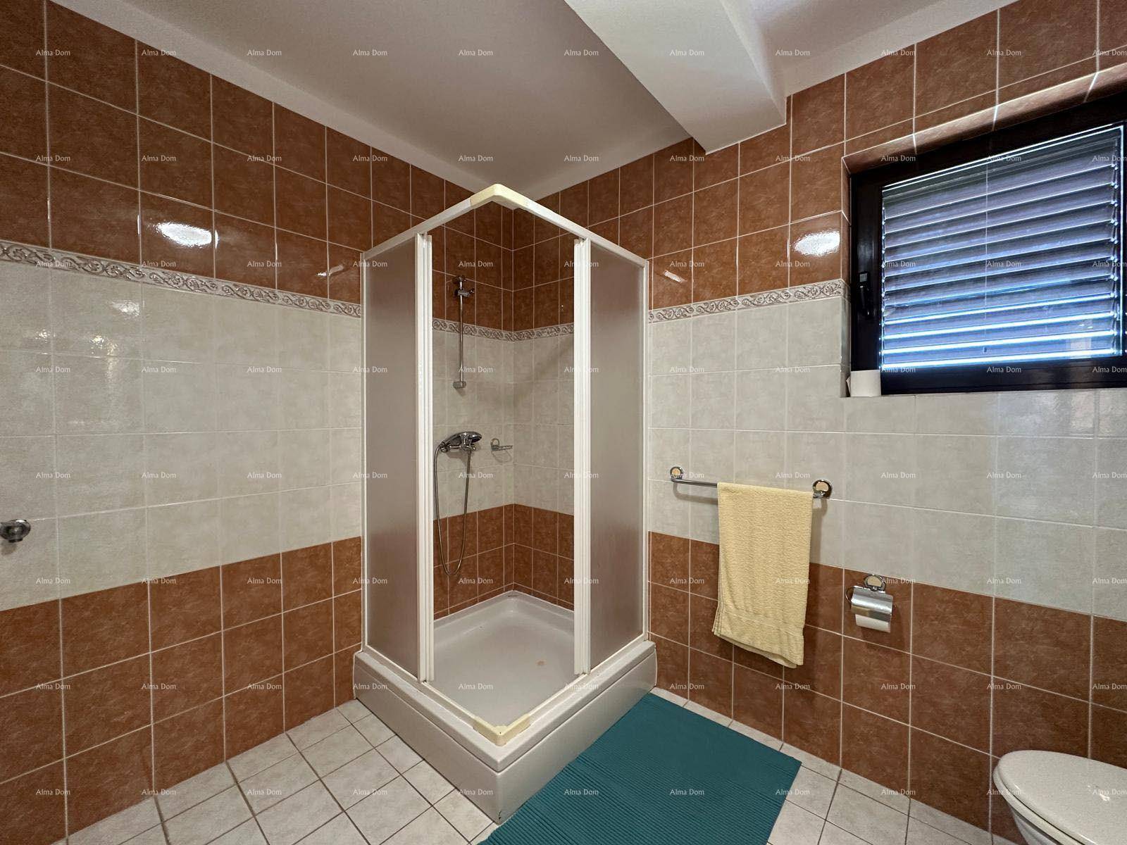Badezimmer mit Eckduschkabine und braun-weißen Fliesen, funktional und hell.