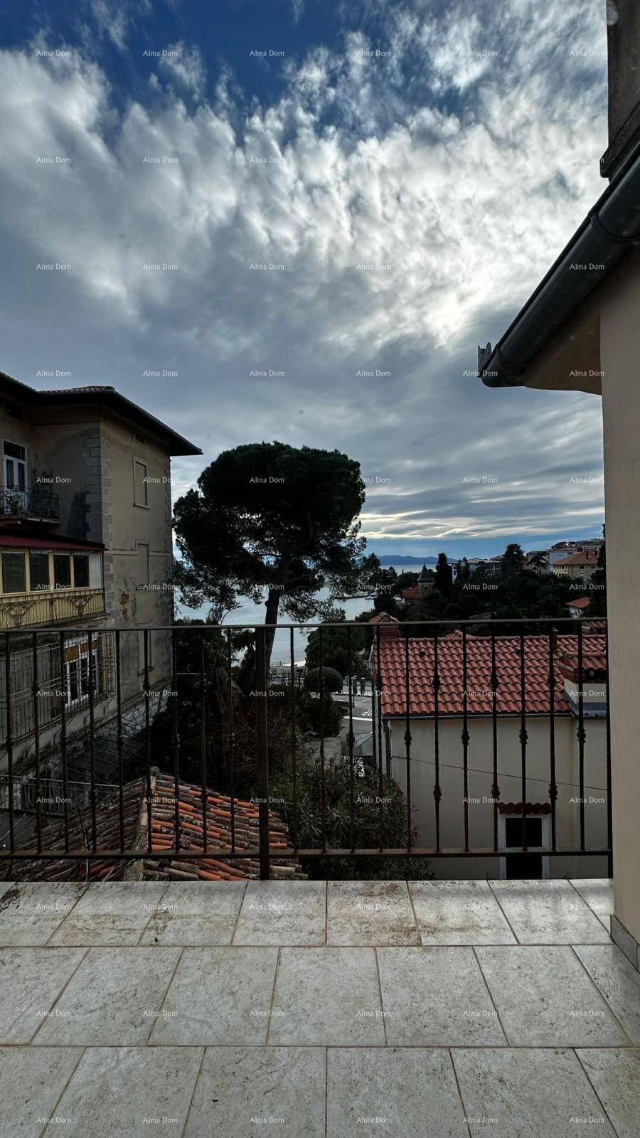 Blick von einem gefliesten Balkon auf das Meer und die umliegende Stadt unter einem bewölkten Himmel.