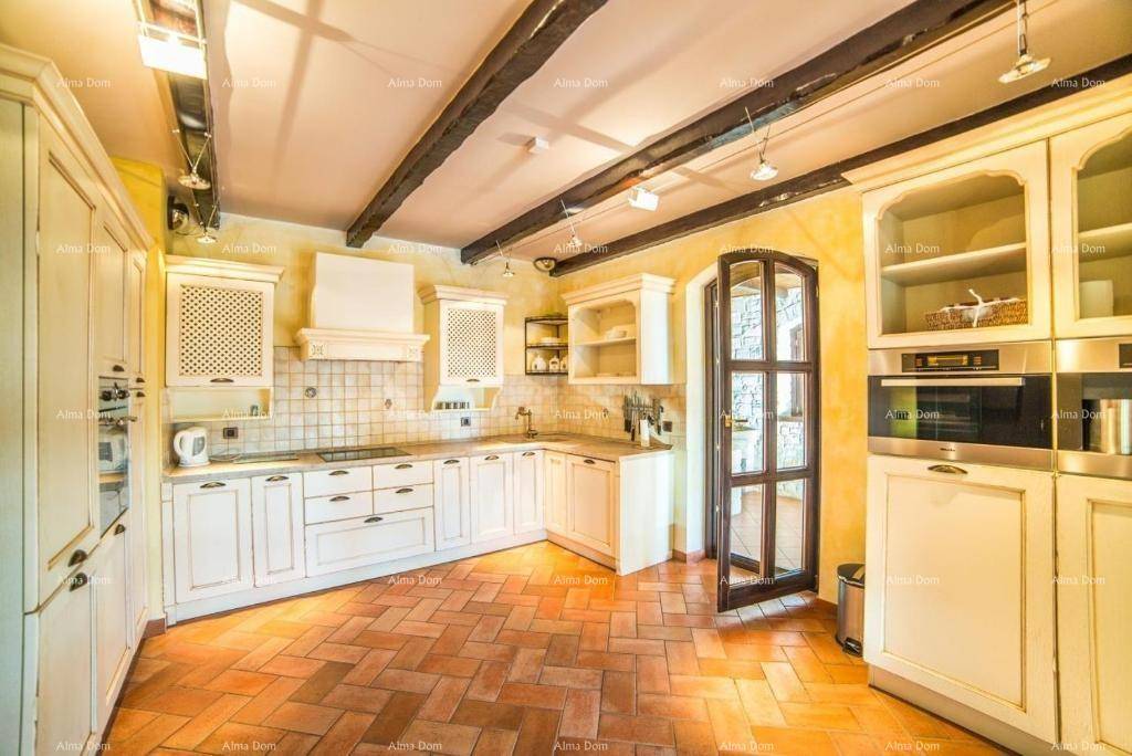 Traditionelle Küche mit weißen Schränken, Terrakottaboden und sichtbaren Holzbalken an der Decke.