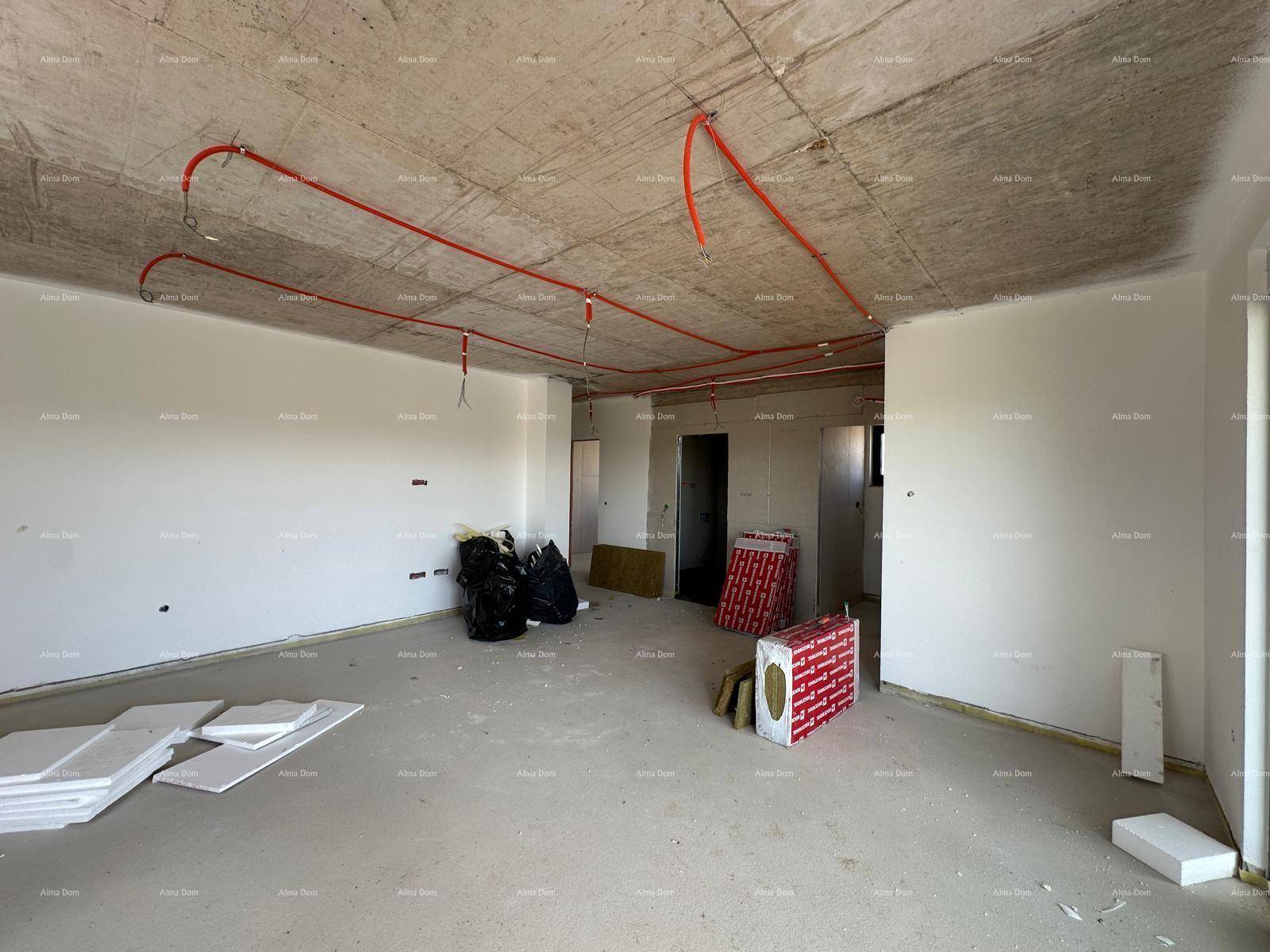 Rohbau eines Zimmers mit sichtbaren Leitungen an der Betondecke und Wänden.
