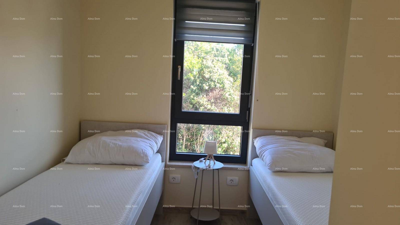 Schlafzimmer mit zwei Einzelbetten, Nachttisch und großem Fenster für viel Tageslicht.