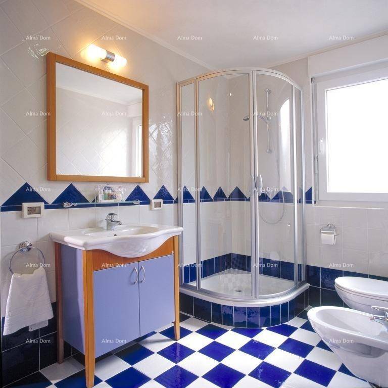 Modernes Badezimmer mit Duschkabine, Bidet und auffälligen blau-weißen Fliesen.