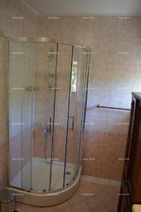 Badezimmer mit Duschkabine, Fenster und beigen Fliesen, funktional und hell.