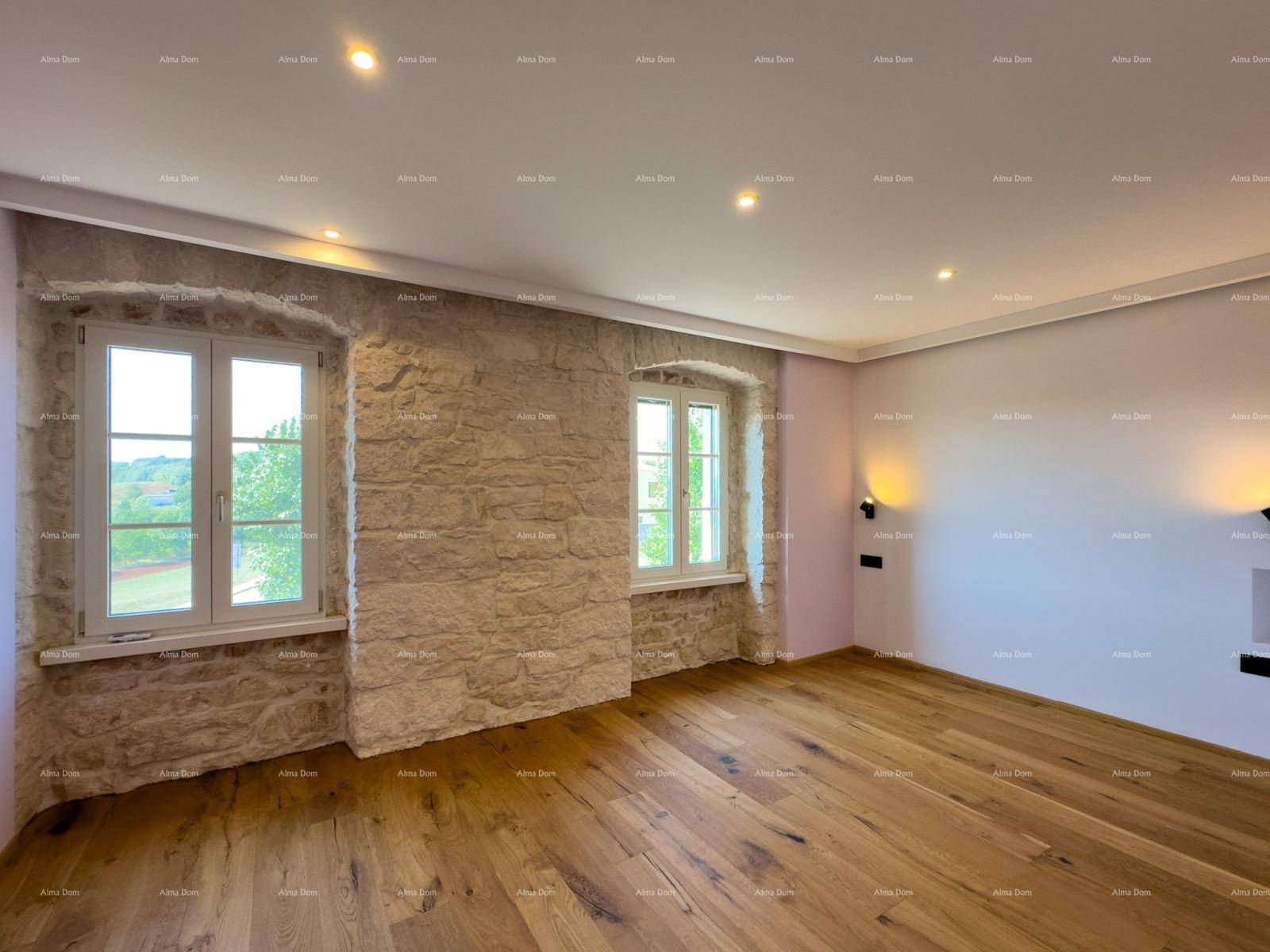 Heller Raum mit Holzboden, freiliegenden Steinwänden und zwei Fenstern.